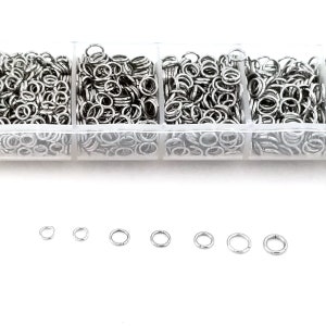 May include: A clear plastic container with four compartments filled with silver jump rings of various sizes. The jump rings are arranged in rows and columns. There are seven individual jump rings of different sizes below the container.