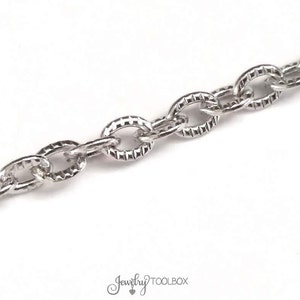 May include: Silver chain with a textured oval link design.