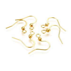 May include: Six gold-toned earring hooks with a small ball at the top. The hooks are made of metal and are designed for attaching earrings.