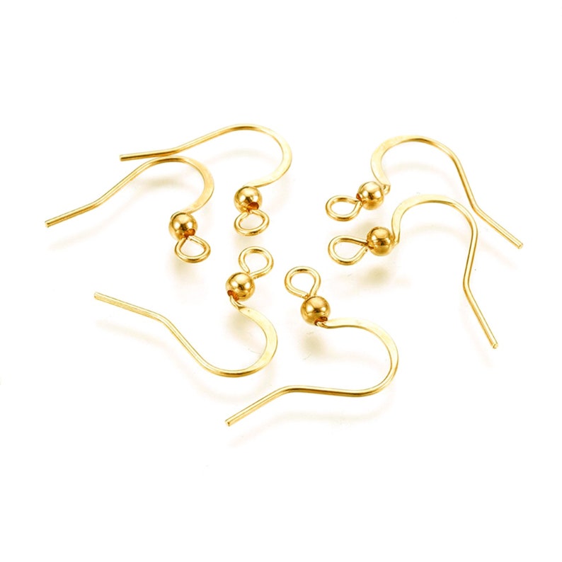 May include: Six gold-toned earring hooks with a small ball at the top. The hooks are made of metal and are designed for attaching earrings.