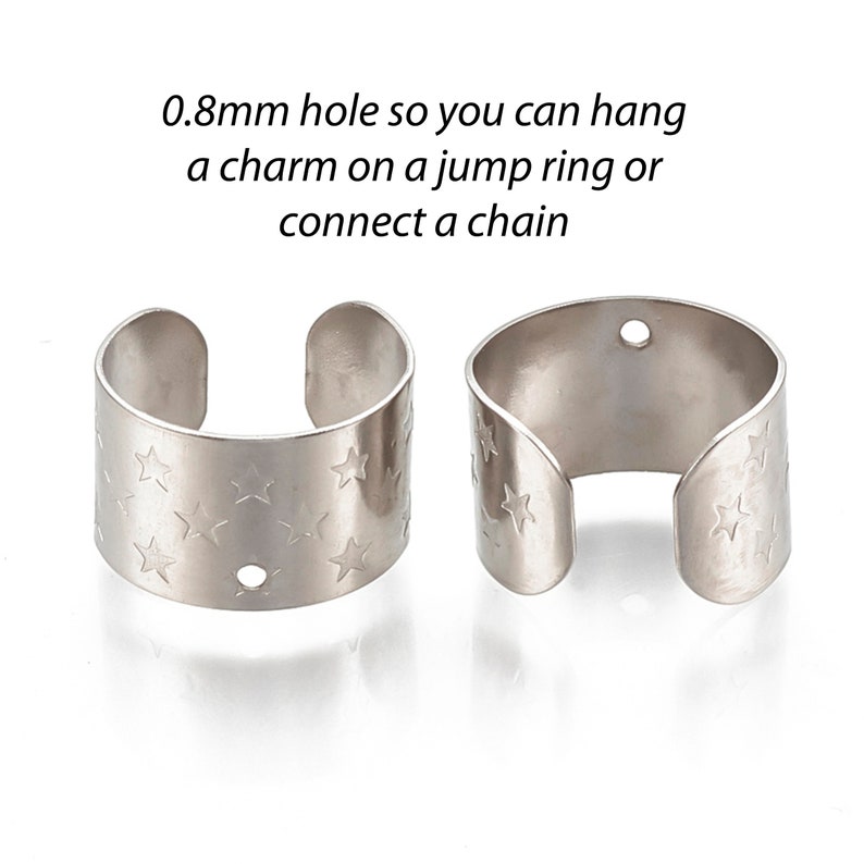 May include: Two silver metal rings with a star pattern and a small hole for attaching a charm or chain. 0.8mm hole so you can hang a charm on a jump ring or connect a chain.