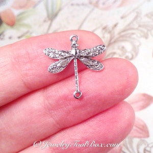 May include: Silver dragonfly charm with a detailed design and two jump rings. The charm is perfect for jewelry making and crafting.