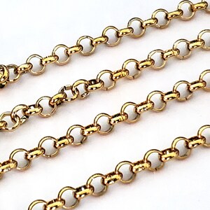 May include: Gold chain necklace featuring a delicate, round link design. The chain is displayed in three layers, showcasing the intricate details of the links.