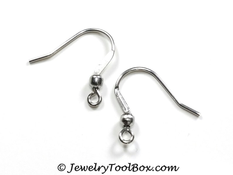 May include: Two silver earring hooks with a small ball at the top of each hook.