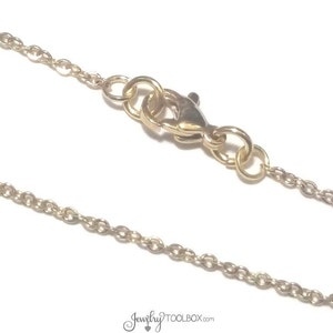 May include: A gold chain necklace with a lobster clasp closure.