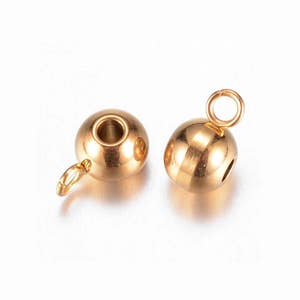 May include: Two gold-toned metal bead caps with a loop on one end. The bead caps are round and have a smooth finish.