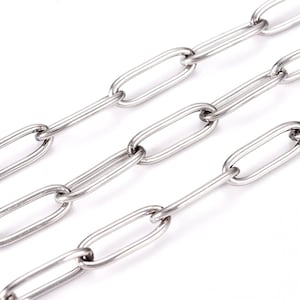 May include: A close-up of a silver chain with oval links. The chain is made of metal and has a shiny finish.