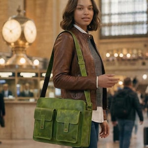 Puede incluir: Un bolso mensajero rectangular de cuero verde oliva con dos bolsillos frontales con cierre de solapa, herrajes en tono latón y una correa ajustable para el hombro. El bolso tiene un acabado liso y mate y se lleva al hombro.