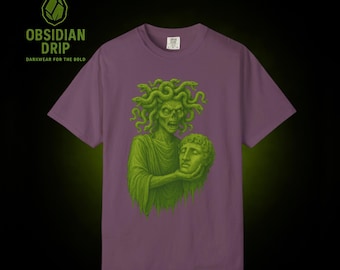 May include: A purple t-shirt featuring a green illustration of Medusa holding a severed head. The design is in a vintage style. The text "OBSIDIAN DRIP DARKWEAR FOR THE BOLD" is in the upper left corner.