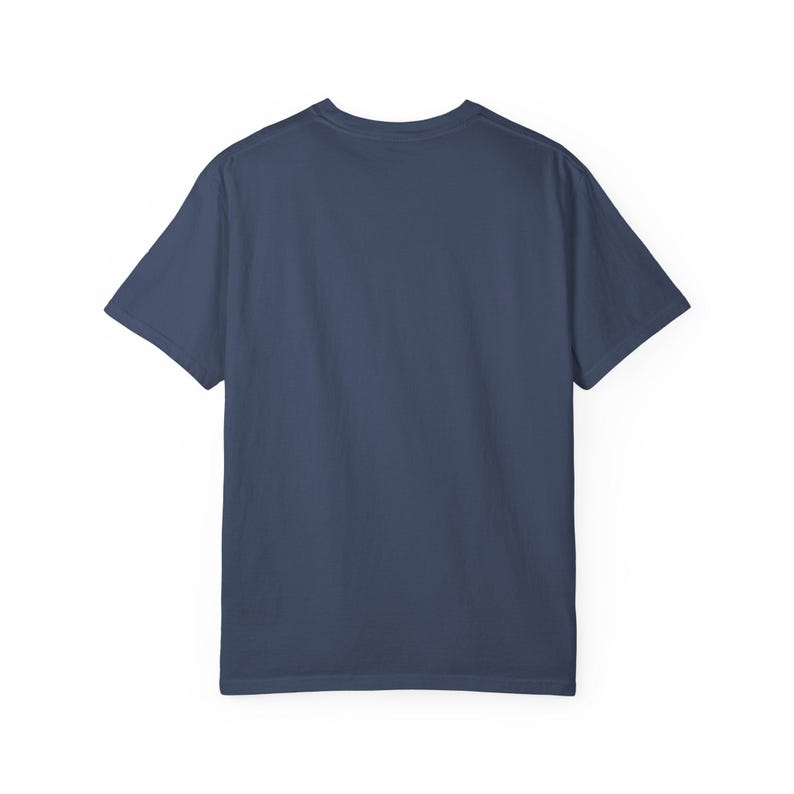 May include: A navy blue short-sleeved t-shirt. The shirt has a crew neck and is made of a soft, solid-colored fabric. The back of the shirt is visible, showing the simple design.