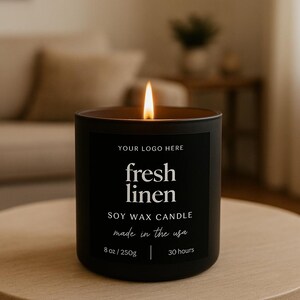 Könnte beinhalten: Eine brennende schwarze Sojawachskerze mit dem Text "fresh linen" auf einem schwarzen Etikett. Die Kerze wiegt 250g und hat eine Brenndauer von 30 Stunden. Das Etikett besagt auch "made in the usa".