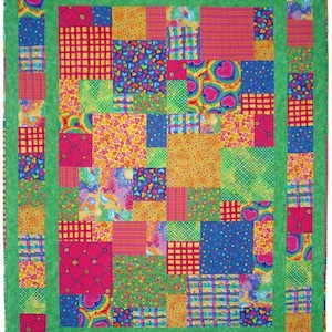 May include: A colorful patchwork quilt with a green border. The quilt is made up of squares of different fabrics, including plaid, polka dots, hearts, and tie-dye.