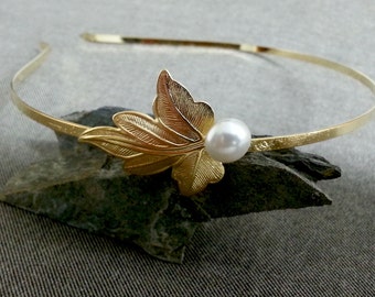 May include: A gold headband with a delicate leaf design and a single pearl accent.