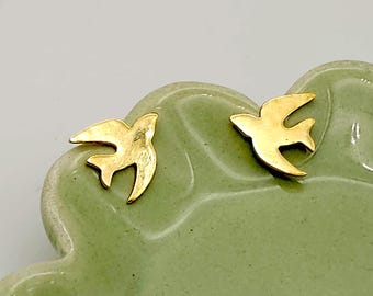May include: A pair of gold-toned bird-shaped stud earrings. The earrings are small and delicate, and they are perfect for adding a touch of whimsy to any outfit.