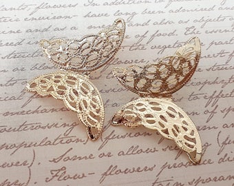 May include: Three gold metal butterfly-shaped charms with intricate cut-out designs. The charms are delicate and have a vintage aesthetic.