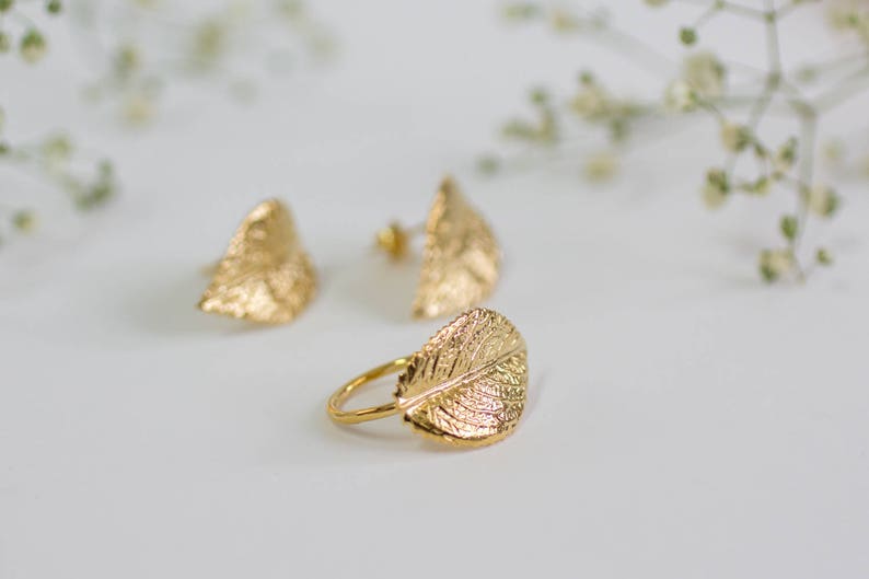 Puede incluir: Un juego de pendientes de hoja de oro y un anillo de hoja de oro. Los pendientes son peque&ntilde;os y delicados, mientras que el anillo es un poco m&aacute;s grande y presenta un dise&ntilde;o m&aacute;s intrincado.