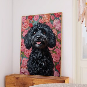 Könnte beinhalten: Gerahmtes Porträt eines schwarzen Hundes mit einem Hintergrund aus rosa Rosen. Der Hund hat ein flauschiges Fell und die Zunge ist zu sehen. Das Kunstwerk wird auf einem Holzschrank in einem Wohnzimmer ausgestellt.