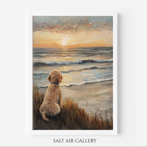 May include: An oil painting depicting a golden-coloured dog sitting in tall grass on a beach, facing the ocean during a sunset with orange and yellow hues in the sky. The text SALT AIR GALLERY is printed in black at the bottom of the white frame.