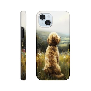 May include: A phone case with a painting of a golden doodle dog in a field, gazing at a landscape. The case is white with a black border and a camera cutout. The dog is a light brown color.
