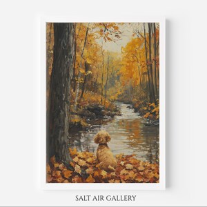 Könnte beinhalten: Gerahmtes Gemälde einer ruhigen Herbstszene. Ein goldfarbener Hund sitzt auf einem Bett aus Herbstlaub und blickt auf einen Fluss. Der umliegende Wald ist voller Bäume mit leuchtend gelbem und orangefarbenem Laub. Der Text "SALT AIR GALLERY" befindet sich unten.