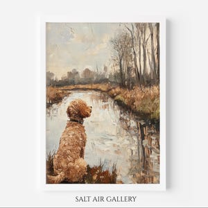 Puede incluir: Una pintura al óleo enmarcada representa a un perro de color dorado sentado junto a un río, mirando el agua. La obra de arte presenta un paisaje sereno con árboles y un cielo nublado. La pintura está firmada "SALT AIR GALLERY" en la parte inferior.