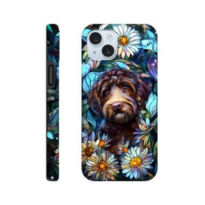 May include: A phone case featuring a brown dog with a stained glass effect. The dog is surrounded by white and yellow daisies and blue leaves. The side of the case is black.