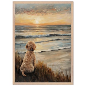 May include: An oil painting in a light wood frame depicting a golden-coloured dog sitting in tall, dry grass on a sandy beach. The dog faces the ocean, where waves roll towards the shore under a sunset sky with orange, yellow, and grey clouds.