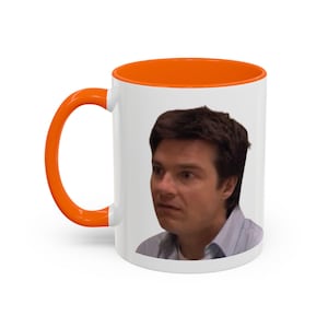 Peut inclure: Mug en céramique blanche avec intérieur et anse orange. L'image imprimée représente un homme avec une expression surprise. Le mug est conçu pour les boissons chaudes et convient à un usage domestique ou au bureau.