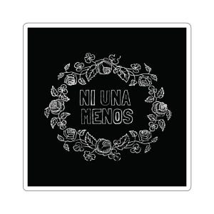 Op de afbeelding: Een zwarte sticker met witte tekst en een bloemenontwerp. De tekst "NI UNA MENOS" staat in een vetgedrukte letter, omringd door een krans van rozen, bladeren en klavervormen. Het ontwerp is eenvoudig en elegant.