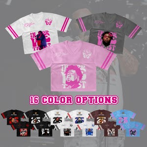 May include: V-neck jersey-style shirts in various colors, featuring graphic designs and text. The shirts have striped sleeves and a butterfly logo. The image also displays the text "16 COLOR OPTIONS".