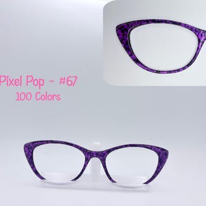 May include: Purple pixel-patterned eyeglasses with a cat-eye shape. The glasses are displayed on a clear stand against a white background. The text "Pixel Pop ~ #67 100 Colors" is in pink script.