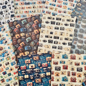 May include: A collection of patterned papers featuring vintage camera designs. The papers display various camera illustrations in colors like blue, red, brown, and black, arranged in repeating patterns. The backgrounds vary from white to dark blue.