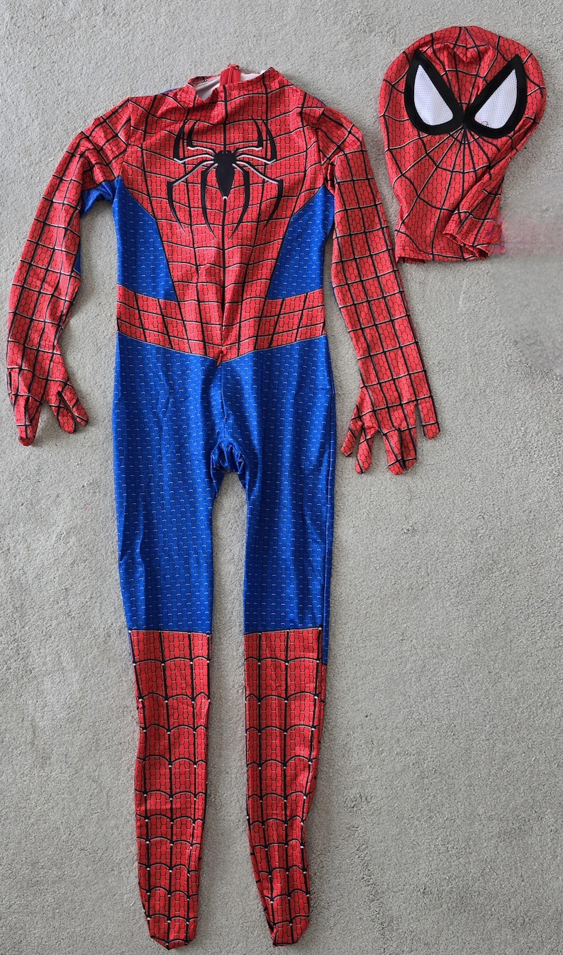 Puede incluir: Un disfraz de Spider-Man rojo y azul con una m&aacute;scara a juego. El traje de cuerpo entero presenta un patr&oacute;n de telara&ntilde;a en las secciones rojas y un emblema de ara&ntilde;a en el pecho. La m&aacute;scara tiene ojos blancos.