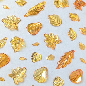 10g de miçangas em formato de folhas de outono, acrílico translúcido laranja em formatos aleatórios, ideais para confecção de bijuterias.