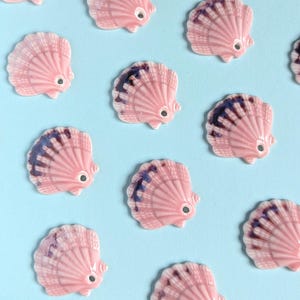 Pode incluir: Um conjunto de três canecas de cerâmica com acabamento fosco e salpicado. As canecas são em tons de creme, cinza claro e cinza escuro. Cada caneca tem um design simples e minimalista e uma alça arredondada.