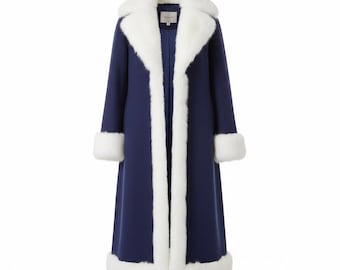 May include: A long, navy blue coat with white faux fur trim. The coat features a large collar, cuffs, and a vertical trim down the front. The coat is a classic design, suitable for cold weather.
