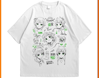 Puede incluir: Camiseta blanca con una ilustración de estilo anime en negro y verde. El diseño incluye múltiples retratos de personajes, texto japonés y la palabra "CURE". La camiseta tiene cuello redondo y mangas cortas.