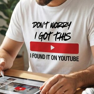 Puede incluir: Una camiseta blanca con el texto "DON'T WORRY I GOT THIS" encima de un rectángulo rojo con un botón de reproducción blanco y el texto "I FOUND IT ON YOUTUBE". La persona está usando una tableta.