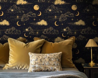 May include: A bedroom scene featuring a dark blue wallpaper with a celestial design of gold moons, clouds, and stars. The bed has gold velvet pillows, a patterned pillow, and a gray blanket. A gold lamp sits on a black nightstand.