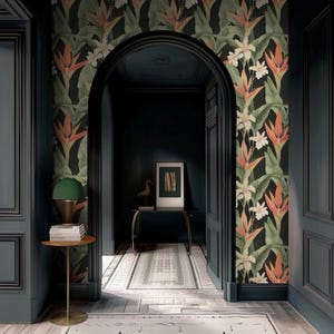 May include: An interior scene featuring a dark teal hallway with a floral wallpaper accent wall. The wallpaper showcases orange and white bird of paradise flowers and green leaves against a black background. A small table with a green lamp and books is on the left.