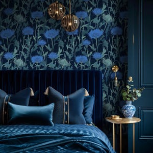 May include: A bedroom scene featuring a navy blue velvet headboard and matching bedding. The focal point is a floral wallpaper with blue thistle-like flowers. Decorative pillows with gold accents and a small side table with a vase complete the elegant decor.