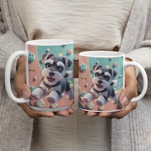 Peut inclure: Deux mugs en céramique blanche avec un motif de chiot Schnauzer. Les mugs ont une anse blanche et un fond bleu clair et rose avec des empreintes de pattes et des os. Le chiot est gris, noir et blanc.