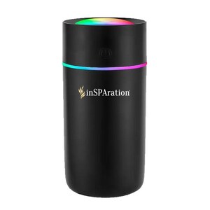 May include: Black cylindrical aromatherapy diffuser with a colorful light band and top. The diffuser has the text "inSPAration" in gold script. The top of the diffuser has a rainbow-colored light.