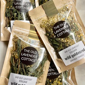 May include: Several clear plastic pouches with brown paper backing containing dried wild goldenrod herbs. Each pouch features a round black label with the text THE OLD LAVENDER COTTAGE and a white rectangular label reading wild goldenrod.