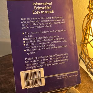 May include: A purple Golden Guide book about bats, featuring text that reads "Informative! Enjoyable! Easy to read!" The book's cover includes information on bat species, habitats, and evolution. The price is $5.95.