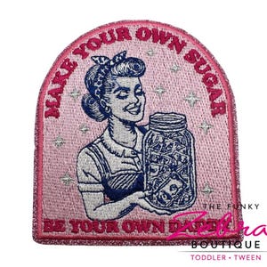 May include: Pink embroidered patch with a retro illustration of a woman holding a jar filled with money. The patch has the text "MAKE YOUR OWN SUGAR" and "BE YOUR OWN DADDY". The Funky Zebra Boutique logo is at the bottom.
