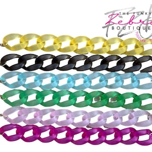 May include: Colorful chain bracelets in yellow, black, light blue, green, lavender, and magenta. Each bracelet features large, oval-shaped links and a silver-colored clasp. The Funky Zebra Boutique logo is in the upper right corner.