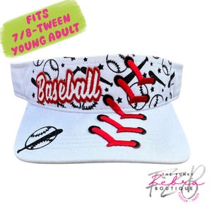 May include: White baseball visor with red stitching details and the word "Baseball" in red. The visor features baseball graphics and the text "FITS 7/8-TWEEN YOUNG ADULT".