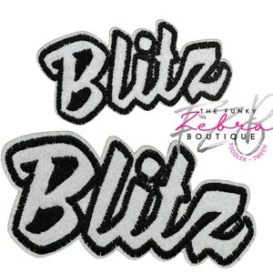 May include: Two embroidered patches with the word "Blitz" in a bold, stylized font. The letters are white with a black outline and a black interior. The patches are on a white background.