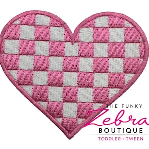 May include: Embroidered heart-shaped patch with a pink and white checkerboard pattern. The patch has a pink border and the text "THE FUNKY Zebra BOUTIQUE TODDLER • TWEEN" in pink script.